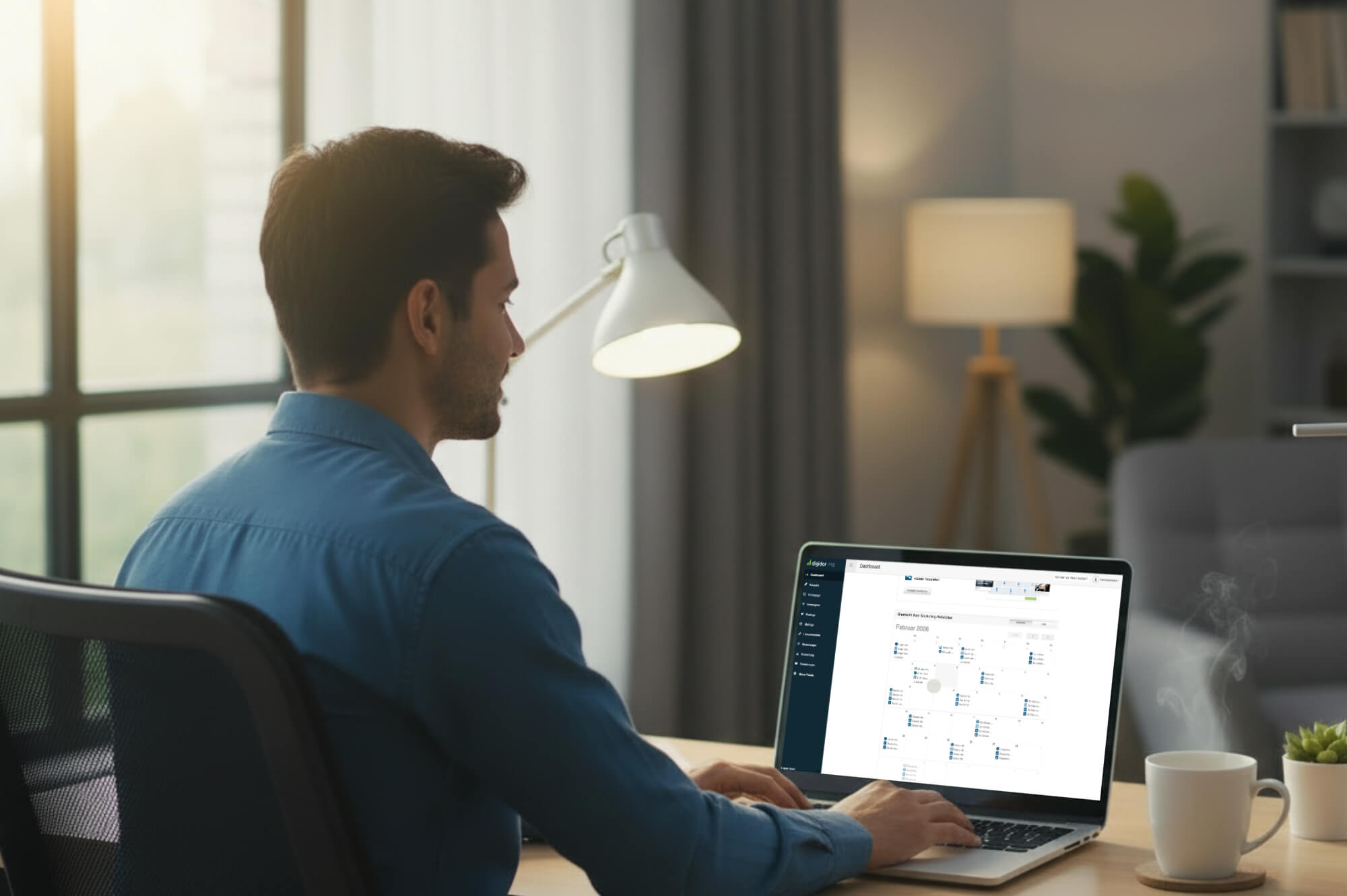 Baufinanzierer arbeitet am Laptop an seiner website automatisierung, Schreibtischlampe und Kaffeetasse daneben