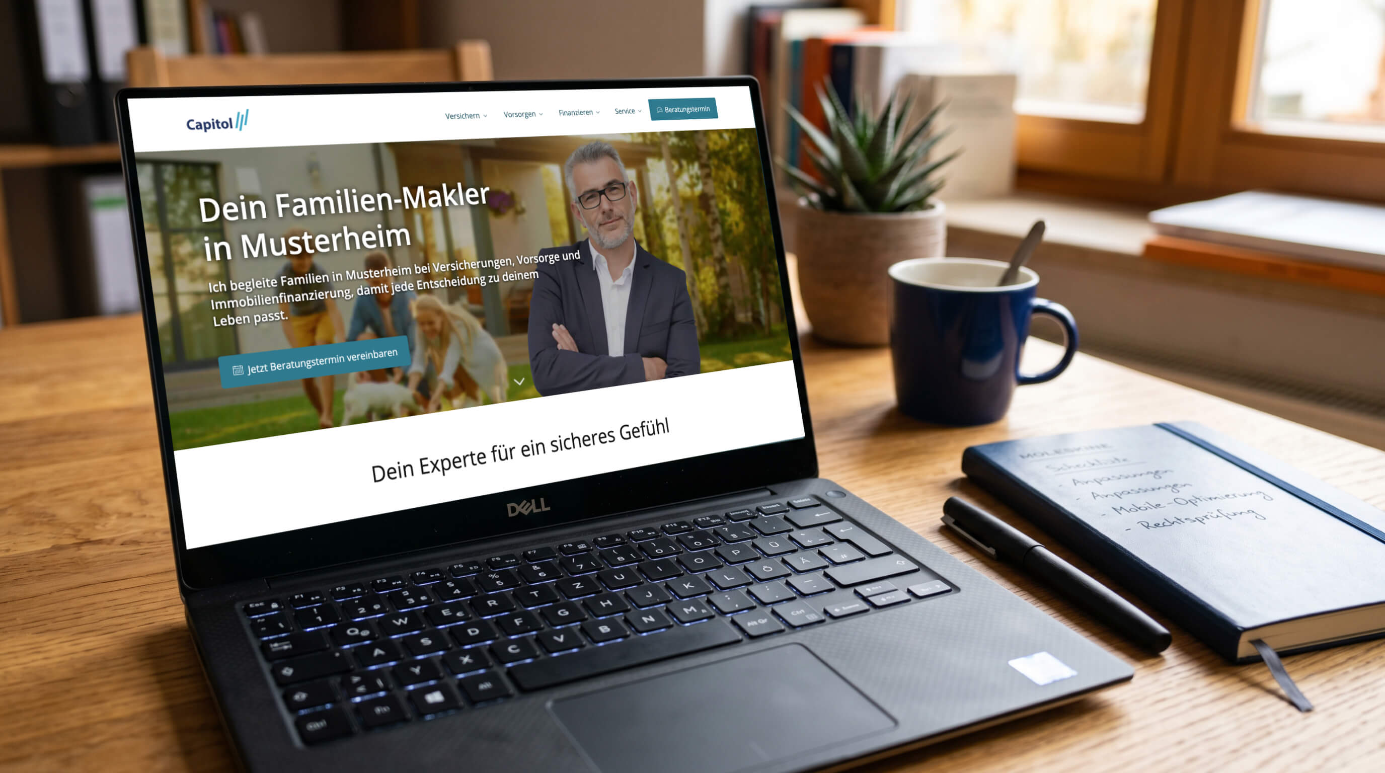 Laptop auf Schreibtisch zeigt Website eines Versicherungsmaklers; daneben Tasse und Notizbuch